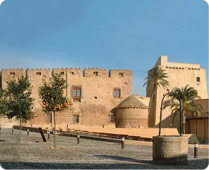 Castillo del Marqués de los Vélez en Cuevas del Almanzora con palmeras y naranjos
